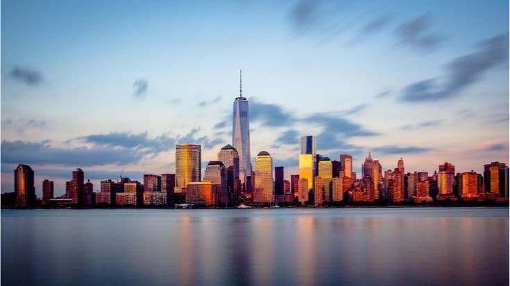 The Lower Manhattan skyline at dusk, with One World Trade Center at its center.